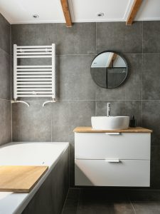 bathroom with dark tiles on the wall